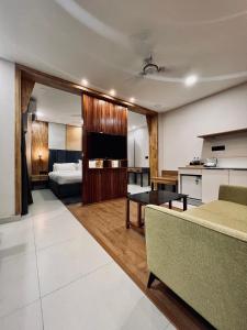 een woonkamer met een bank en een televisie bij The Habitat Suites in Guruvāyūr