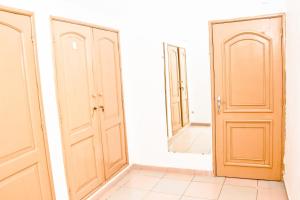 una habitación vacía con dos puertas y un espejo en GP HOUSES 3, en Cotonou