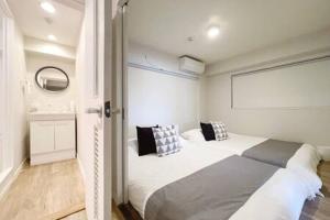 1 Schlafzimmer mit 2 weißen Betten in einem Zimmer in der Unterkunft bHOTEL Dai3Himawari - Amazing Dome View 30 sec PeacePark, Up to 10 ppl in Hiroshima