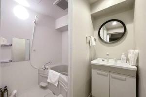 ein weißes Badezimmer mit einem Waschbecken und einem Spiegel in der Unterkunft bHOTEL Dai3Himawari - Amazing Dome View 30 sec PeacePark, Up to 10 ppl in Hiroshima