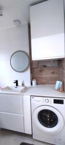 a laundry room with a washing machine and a mirror at Appartement Cosy à 10min de la Villette & du Philharmonie Paris in Le Pré-Saint-Gervais