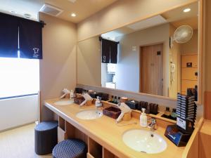 a bathroom with two sinks and a large mirror at Dormy Inn Ueno Okachimachi in Tokyo