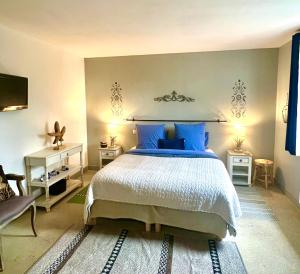 1 dormitorio con 1 cama grande con almohadas azules en GSand Le Clos du May en Le Poinçonnet