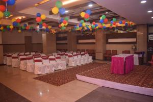 a banquet hall with white chairs and balloons and a pink box at HOTEL DHIRAJ in Thane