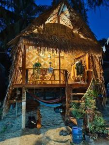 een kleine hut met een boot in het zand bij Malee homestay in Ko Por