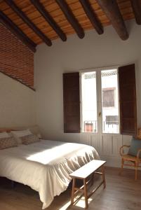 1 dormitorio con 1 cama blanca grande y 1 silla en Paz y Lavanda, en Valdelaguna