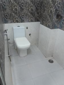 a bathroom with a white toilet and a shower at Hotel Star Inn - Delhi Airport, Mahipalpur, Aerocity in New Delhi