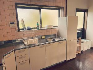 a kitchen with a white refrigerator and a sink at yadori TEN 宿り　甸 