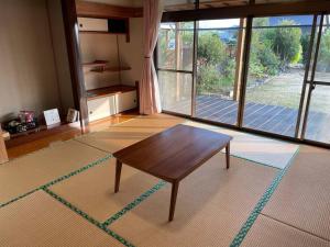 a living room with a table and a large window at yadori TEN 宿り　甸 
