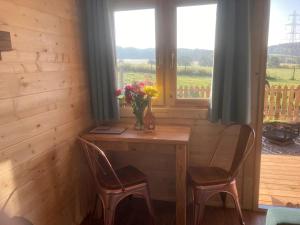 een houten tafel met twee stoelen en een vaas met bloemen bij Captivating 1-Bed Lodge in Chesterfield in Chesterfield