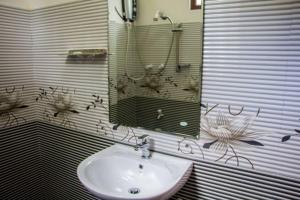 uma casa de banho com um lavatório e um espelho em VRK Adventure Base Camp em Kitulgala