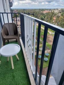 a chair and a table on a balcony with a view at Kay homes in Nairobi