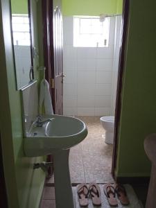 a bathroom with a sink and a toilet and two shoes at Kay homes in Nairobi