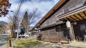 un homme se tient à l'extérieur d'un bâtiment dans l'établissement Matsunoki-tei, à Otari