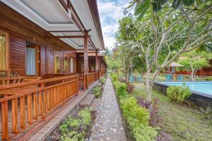 a house with a garden and a swimming pool at Putri Nusa Beach in Nusa Penida