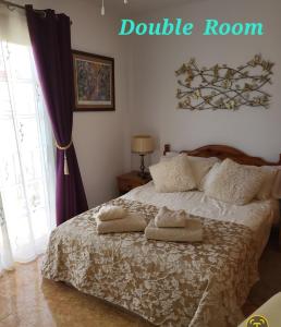 1 dormitorio con 1 cama con 2 toallas en Casa Mariposa Guesthouse en Playa de San Juan