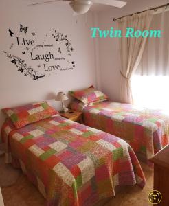 a bedroom with two beds and a twin room at Casa Mariposa Guesthouse in Playa de San Juan