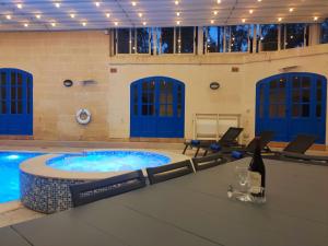 a pool with a hot tub in a building at Margerita Farmhouse in Qrendi