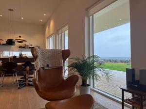 - un salon avec une grande fenêtre et une table à manger dans l'établissement Oceanfront & Aurora Dreamscape Villa, à Álftanes