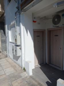 een witte muur met een deur en een raam bij IN25G in Thessaloniki