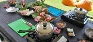 a table with a tea kettle and food on it at Indah Homestay and Cooking classes in Senggigi