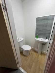 La salle de bains est pourvue de toilettes et d'un lavabo. dans l'établissement VicVic Guest house, à Oldham