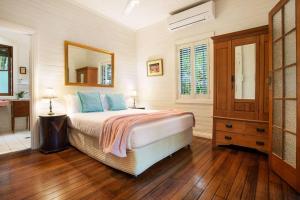 a bedroom with a bed and a mirror and a bathroom at Coco's Cottage in the Byron Bay Hinterland in Bangalow