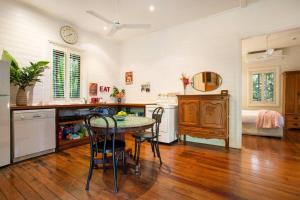 a kitchen with a table and chairs and a bed at Coco's Cottage in the Byron Bay Hinterland in Bangalow