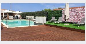 un cortile con piscina, sedie e recinzione di Sicilia Hotel Spa a Giarre