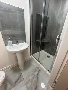 a bathroom with a sink and a shower at VicVic Guest house in Oldham