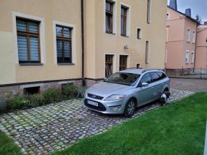 una macchina argentata parcheggiata di fronte a un edificio di gemütliche Ferienwohnung a Burgstaedt