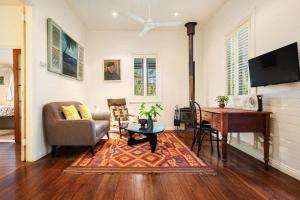 een woonkamer met een bank, een tafel en een piano bij Coco's Cottage in the Byron Bay Hinterland in Bangalow