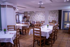 a dining room with white tables and wooden chairs at Casa Rural El Cartero in Abionzo