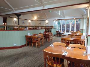 comedor con mesas y sillas de madera en Orton Hall Hotel & Spa, en Peterborough