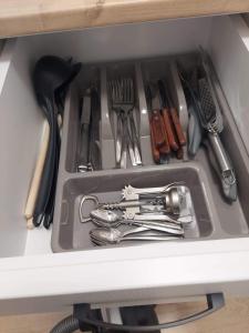 a drawer filled with utensils on a shelf at ALDIRA Studio Arena Nationala in Bucharest