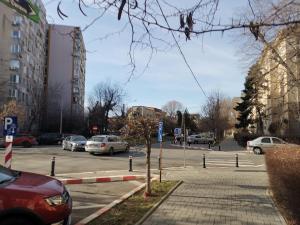 a city street with cars parked in a parking lot at ALDIRA Studio Arena Nationala in Bucharest