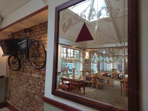 um reflexo de uma sala de jantar com uma bicicleta na parede em Orton Hall Hotel & Spa em Peterborough