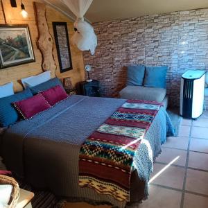 a bedroom with a large bed and a couch at Casa kintsugi in Masquefa