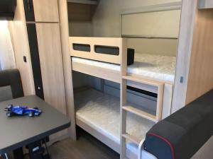 a small room with two bunk beds and a desk at Delightful RV Camper In a Peaceful Area near Sea. in Skála Foúrkas