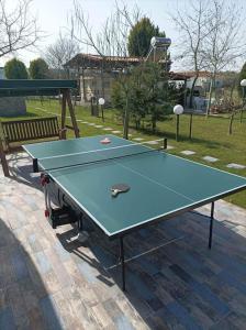 a ping pong table in a park with a bench at Delightful RV Camper In a Peaceful Area near Sea. in Skála Foúrkas