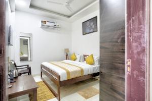 um quarto com uma cama e uma secretária num quarto em The Noble Suites, Near Spectrum Mall em Noida