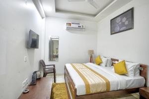 a bedroom with a bed and a chair in it at The Noble Suites, Near Spectrum Mall in Noida
