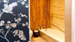 埃森的住宿－Dream home，浴室拥有蓝色和白色的壁纸,配有浴缸。