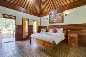 a bedroom with a bed in a room with wooden walls at Putri Nusa Beach in Nusa Penida