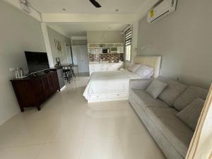 een woonkamer met een bed en een bank bij INATO SUITES Rm 2 2 queen beds in Panglao