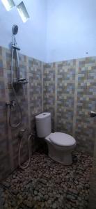 a bathroom with a toilet and a shower at Umah isun guests house in Banyuwangi