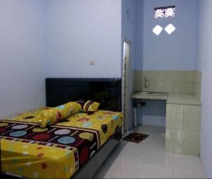 a bedroom with a bed and a sink in it at Umah isun guests house in Banyuwangi