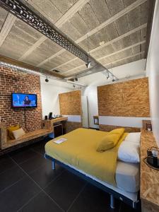 a bedroom with a bed and a brick wall at La Maraudeuse in Theux