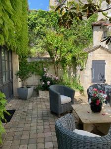 a patio with wicker chairs and a table and a table and chairs at Gite MCM in Chalais
