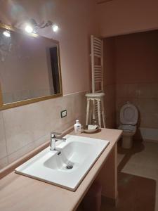 een badkamer met een wastafel, een spiegel en een toilet bij B&B Rosita in Patti